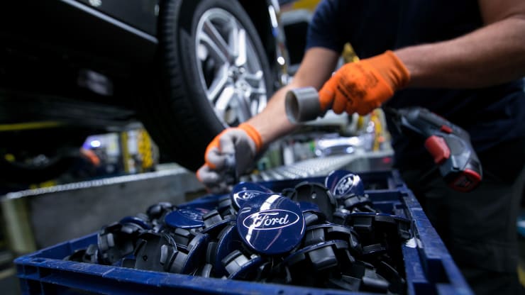 A worker puts the Ford logo on wheels in Germany